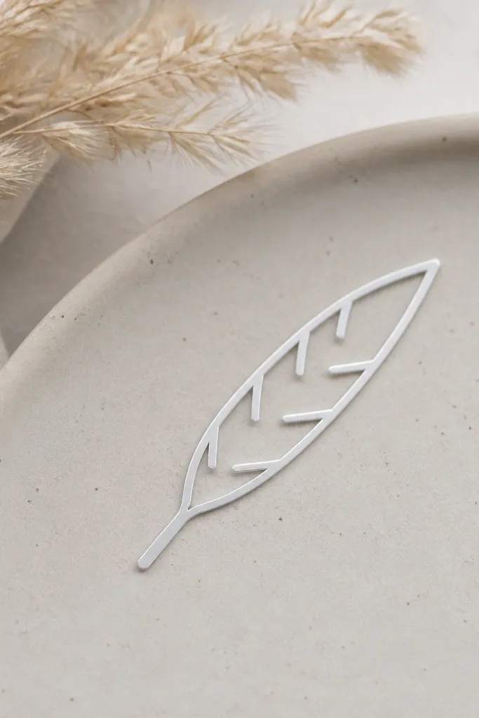 A small feather tip stencil with a tapered end and a few evenly spaced inner lines. The outer feather outline is thin and the internal lines are short.