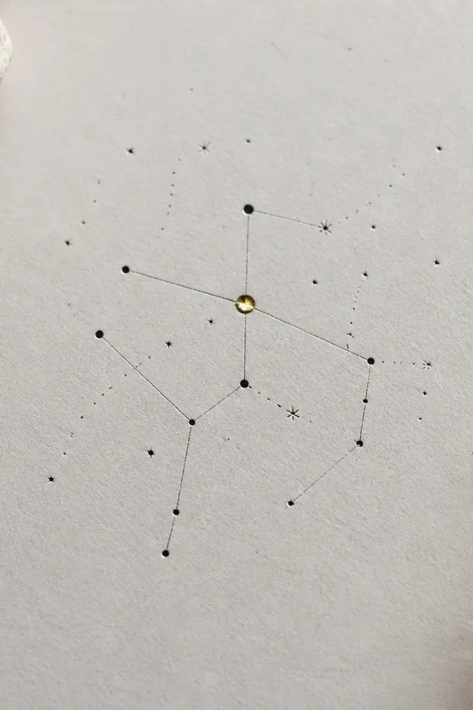 A constellation made of thin black dots and lines, with one single jewel-like dot in muted gold or pale yellow. The rest is black and light gray.