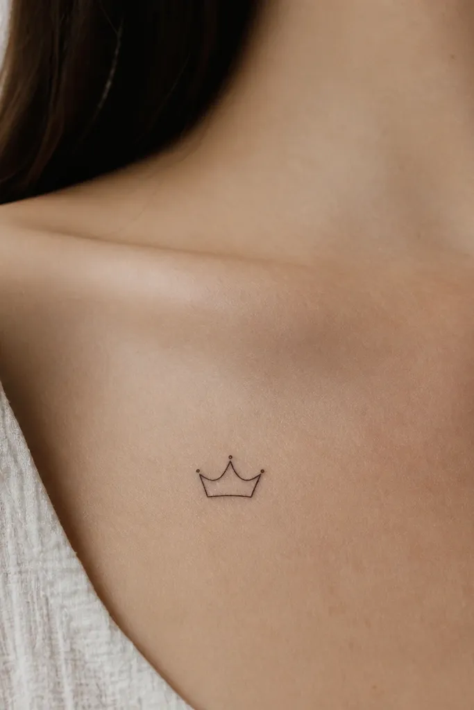 A small crown-like arc drawn in thin black ink. It has three short points on top, with the base line sitting close to the skin. The space inside the crown is completely blank.