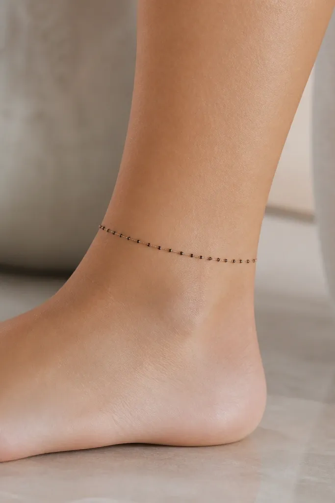 A thin chain line around the ankle made of small black dots connected by tiny gaps. Each "link" is more dots than outline, giving a soft shimmer effect.