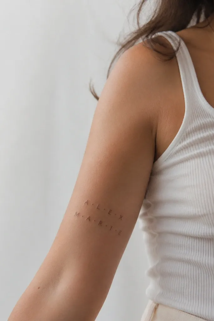 Two lines of a name on the inner arm, with small evenly spaced dot separators between parts of the name.