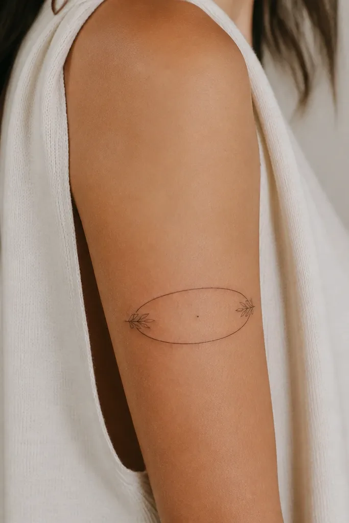 A small oval wreath wraps the upper arm, made from two leaves and a thin outline, with a single dot in the center.